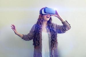 Sorridi giovane donna indossare utilizzando virtuale la realtà vr bicchieri casco cuffia su bianca sfondo. smartphone utilizzando con virtuale la realtà occhiali. tecnologia, simulazione, hi-tech, video gioco concetto. foto