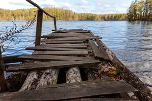 lago o fiume della foresta il giorno d'estate e vecchio molo o molo in legno rustico foto