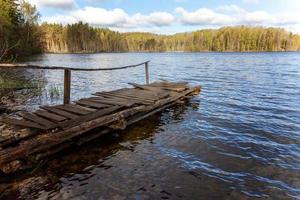 lago o fiume della foresta il giorno d'estate e vecchio molo o molo in legno rustico foto