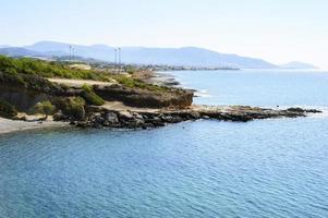 bellissima laguna blu con acqua di mare limpida e una spiaggia di ciottoli e scogli foto