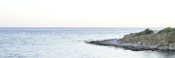 vista sul mare con rocce al mattino presto o in tarda serata foto