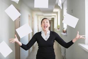 un' donna nel il ufficio disperde carte. nervoso dipendente. foto