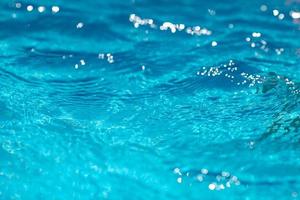 avvicinamento di blu acqua nel il piscina. lato Visualizza. bokeh leggero sfondo nel il piscina. foto