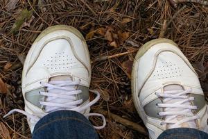 gambe nel un' sneaker su un' foresta sfondo foto