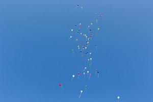 molti colorato palloncini nel il blu cielo foto