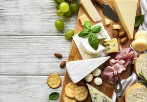 vari tipi di formaggio su uno sfondo bianco di legno foto