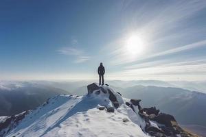 uomo in piedi su il superiore di un' Innevato montagna picco. panoramico Visualizza foto