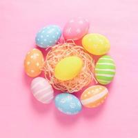 contento Pasqua vacanza saluto carta concetto. colorato Pasqua uova su pastello rosa sfondo. piatto posizione, superiore Visualizza, copia spazio. foto