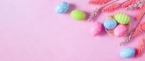 contento Pasqua vacanza saluto carta concetto. colorato Pasqua uova e primavera fiori su pastello rosa sfondo. piatto posizione, superiore Visualizza, copia spazio. foto