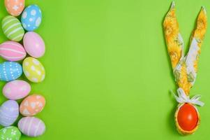 contento Pasqua vacanza saluto carta design concetto. colorato Pasqua uova e primavera fiori su pastello verde sfondo. piatto posizione, superiore Visualizza, copia spazio. foto