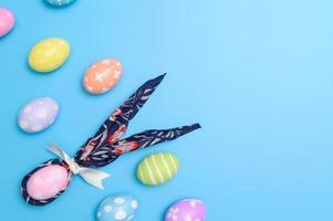 contento Pasqua vacanza saluto carta design concetto. colorato Pasqua uova e primavera fiori su blu sfondo. piatto posizione, superiore Visualizza, copia spazio. foto