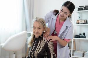 badante per un anziano donna settimanalmente controlli a il del paziente residenza. pronto per dare medico consigli e parlare di vario storie, scambio ogni altro felicemente. foto