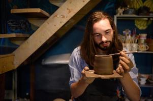 ceramica artista, giovane fabbricazione un' pezzo di argilla modanatura con calma e meticolosamente nel ordine per produrre il maggior parte attraente opera possibile, foto