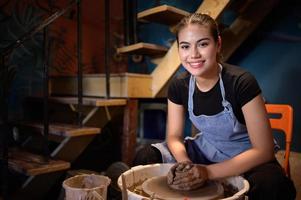 ceramica artista, giovane femmina fabbricazione un' pezzo di argilla modanatura con calma e meticolosamente nel ordine per produrre il maggior parte attraente opera possibile, foto