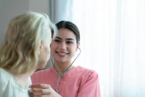 badante per un anziano donna settimanalmente controlli a il del paziente residenza. pronto per dare medico consigli e parlare di vario storie, scambio ogni altro felicemente. foto