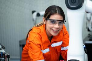 nel un elettronico parti facilità, femmina ingegneri nel il pianta, ispezionando e analisi robotica mani Usato nel il produzione di elettronico componenti. foto