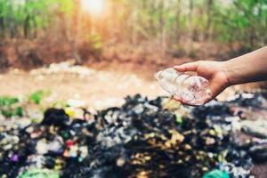 mano Tenere spazzatura plastica bottiglia per pulito foto