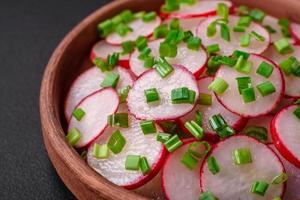 delizioso fresco insalata di affettato Ravanelli con verde cipolle, sale e oliva olio foto