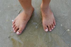 piedi in piedi su sabbia spiaggia concetto sfondo foto