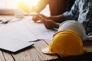 costruzione e struttura concetto di ingegnere Lavorando disegno su planimetria incontro per progetto Lavorando con compagno su modello edificio e ingegneria utensili nel Lavorando luogo, costruzione concetto foto