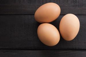 tre uova di gallina fresche su un tavolo di legno foto