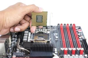 mano che tiene una CPU e una presa della scheda madre per una CPU isolata su sfondo bianco foto