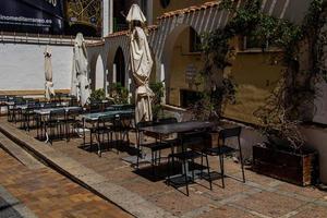 l urbano paesaggio di un' spagnolo strada nel benidorm con un' bar e tavoli su il marciapiede senza persone foto