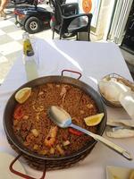 caldo spagnolo paella con frutti di mare e gamberi e un' cucchiaio foto