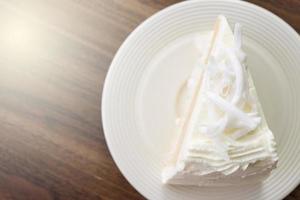 un pezzo di torta al cocco su un piatto bianco foto