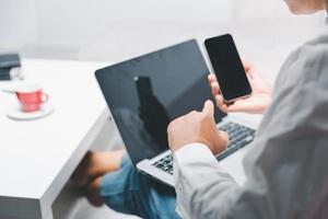 sociale media giorno concetto. femmina libero professionista di partenza Lavorando giorno presto nel vivente camera per sito web con smartphone. donna d'affari Lavorando nel casa ufficio. donna comunicare con in linea tecnologia. foto