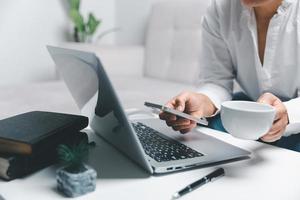 sociale media giorno concetto. femmina libero professionista di partenza Lavorando giorno presto nel vivente camera per sito web con smartphone. donna d'affari Lavorando nel casa ufficio. donna comunicare con in linea tecnologia. foto