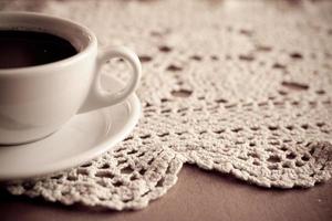 bianca tazza con nero caffè su un' fatti a mano tovaglia foto