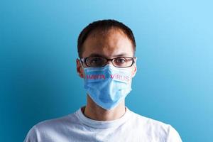 testo hantavirus, uomo rimuove protettivo maschera a partire dal viso dopo infetto Cinese virus. uomo nel medico maschera su blu sfondo. sintomi di hanta virus, hp virus infezione. foto