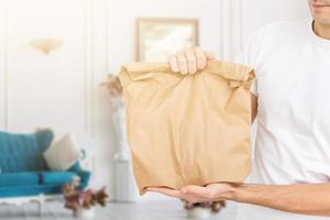 giovane uomo consegna cibo per cliente a portone foto