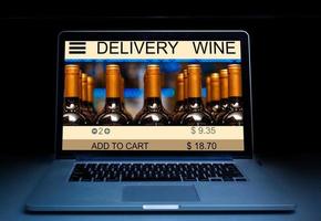 avvicinamento foto di vino consegna su un' il computer portatile tenere sotto controllo