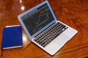 il computer portatile con grafici di finanziario crisi foto