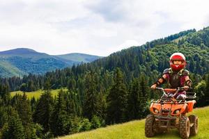 ragazza equitazione quadrilatero bicicletta montagna, atv. carino bambino su quadriciclo. bambini estate vacanza attività. foto