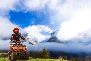 ragazza equitazione quadrilatero bicicletta montagna, atv. carino bambino su quadriciclo. bambini estate vacanza attività. foto