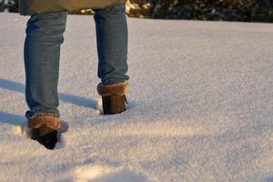 primo piano di una persona che cammina nella neve foto