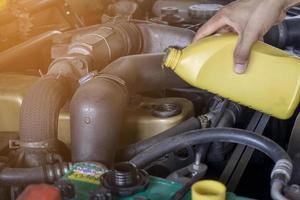 chiudere un meccanico che fa servizio e manutenzione dell'auto, riparazione del cambio dell'olio e del filtro del carburante foto