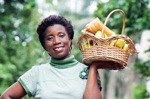 giovane donna con un cesto di frutta in mano e andare a fare un picnic foto