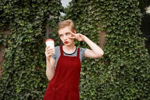 donna con corto capelli all'aperto nel estate tazza di caffè foto