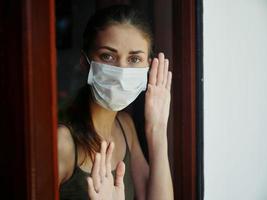 donna medico maschera nel finestra bandire lockdown foto