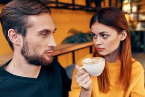 un' donna nel un' maglione e un' uomo nel un' bar un' tazza di caffè coppia nel amore amici famiglia foto