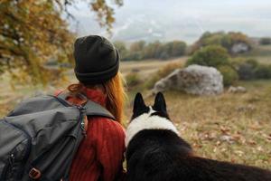 donna escursionista a piedi il cane nel il montagne natura viaggio paesaggio foto