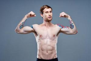 forte maschio atleta con pompato su braccio muscoli e tatuaggio bodybuilder fitness foto