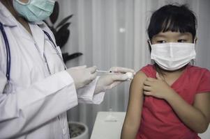 asiatico medico iniezione vaccino per proteggere virus covid-19 per un' ragazza indossare medico maschera, persone siamo ragazze siamo vaccinati contro influenza ogni anno. foto