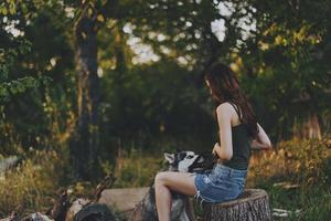 donna e sua rauco cane felicemente giocando all'aperto nel il parco tra il alberi Sorridi con denti nel il autunno camminare con sua animale domestico foto