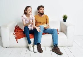 uomo e donna Guardando film in casa con Popcorn e fiore nel un' pentola foto