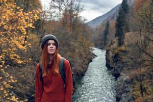 donna escursionista con zaino nel il montagne autunno foresta fiume paesaggio foto